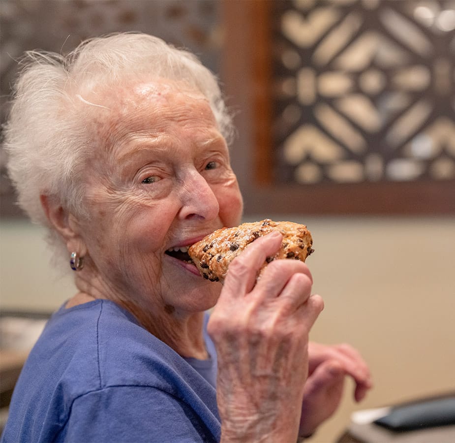 elderly woman enjoying a pastry