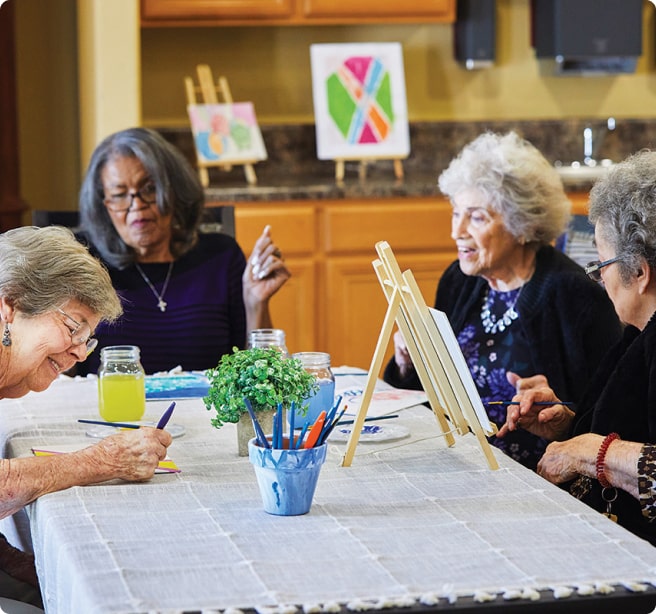 group of elderly woman sitting at a table painting group of elderly woman sitting at a table painting