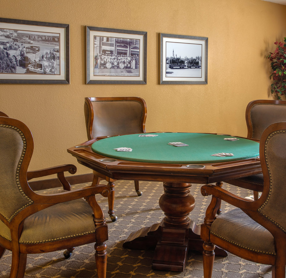 Activities & Events A poker table with multiple painting on the wall behind