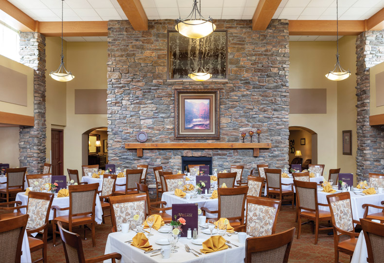 Hapenings Warm dining room with a brick wall and fireplace, each table elegantly arranged with silverware