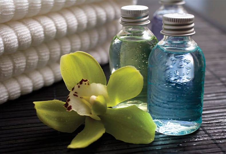 The Fountains at the Albemarle Indulge Salon & Spa A vibrant green floral next to bottles of botanicals atop a wooden table