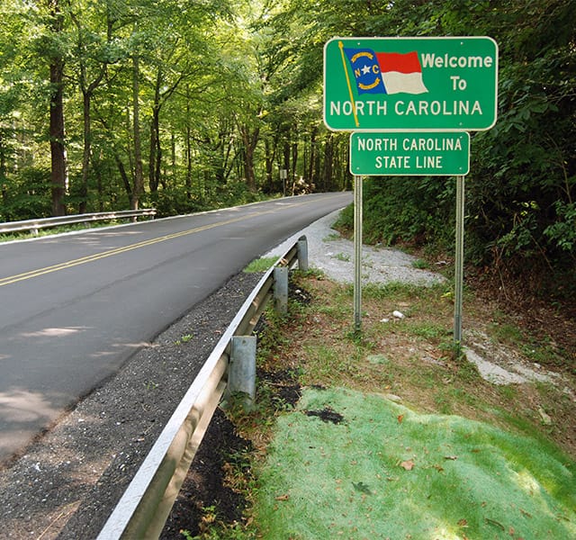 The Fountains at the Albemarle The Neighborhood - North Carolina A 'Welcome to North Carolina' sign along the side of the highway crossing the state line