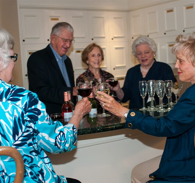 The Fountains at Albemarle Independent Living A group of residents enjoying red and white wine during a social evening as part of the independent living program