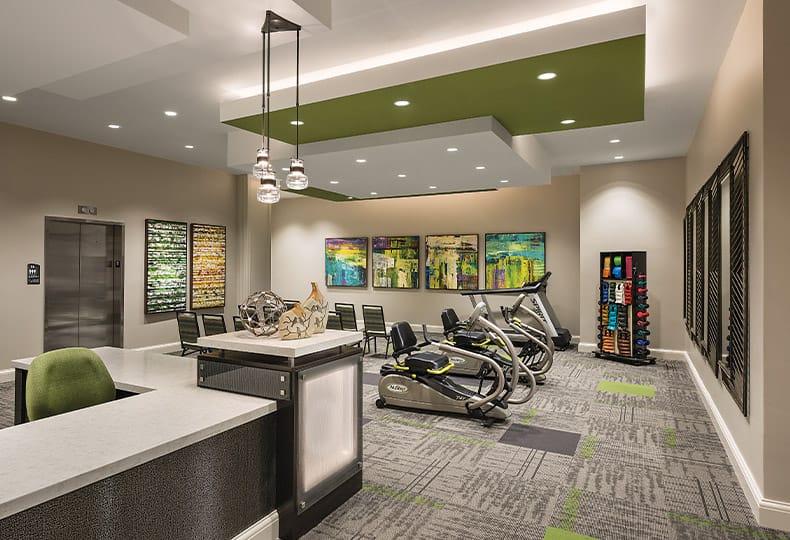 The Preston at the Park Cities Fitness First floor wellness room feature free weights and cardio equipment