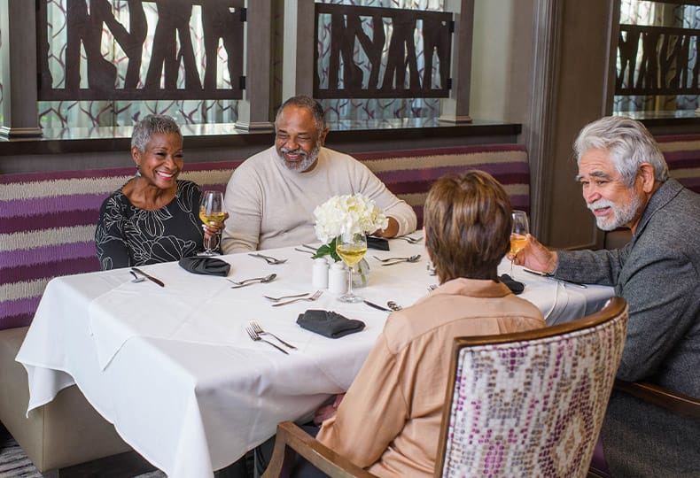 The Preston at the Park Cities Happenings A group of residents seated in a booth in one of the on-site dining establishments at the Preston at the Park Cities