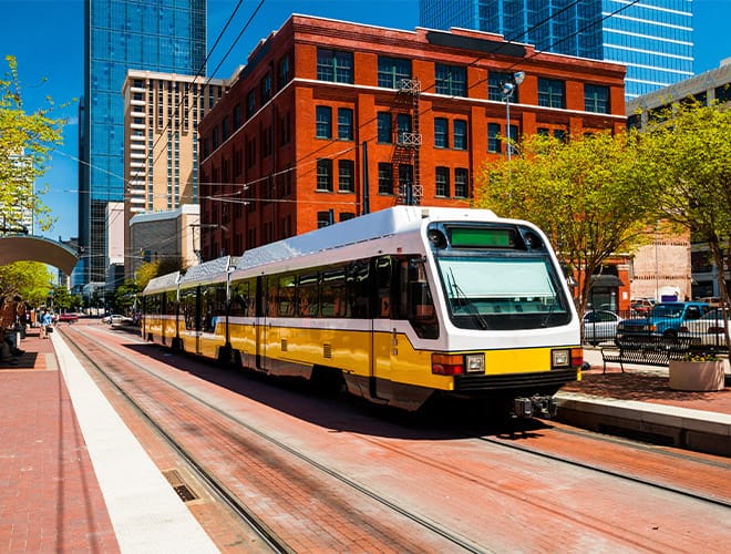 The Preston at the Park Cities Partnerships Wide angle view of a DART light rail train at a station in downtown Dallas.