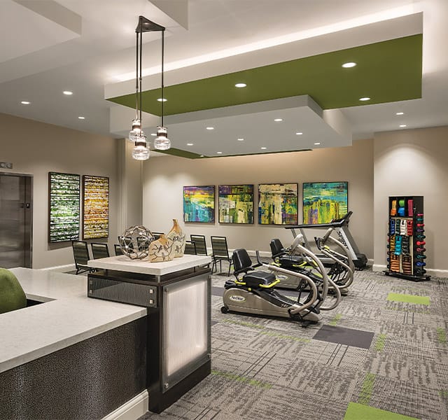 The Preston at the Park Cities Fitness First floor wellness room feature free weights and cardio equipment