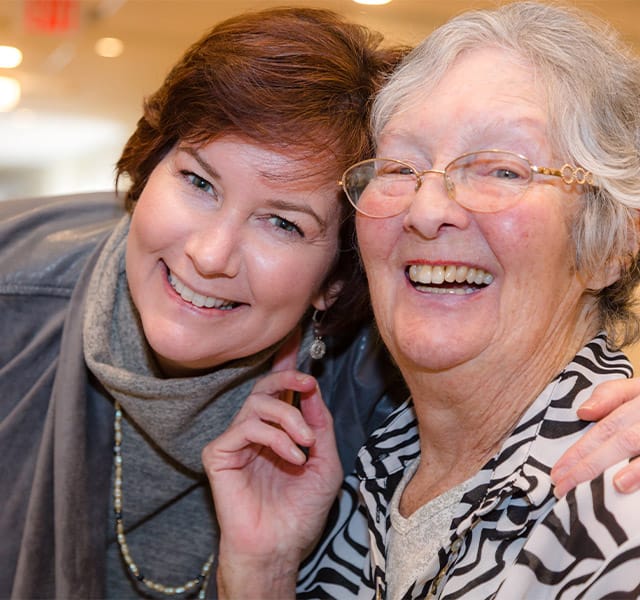 elderly woman and her daughter laughing elderly woman and her daughter laughing