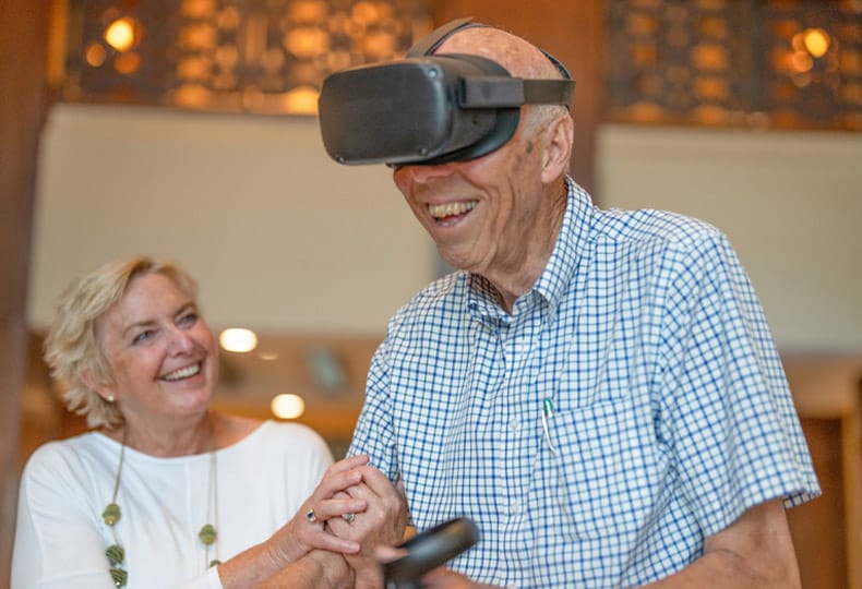 elderly couple laughing while enjoying virtual reality event elderly couple laughing while enjoying virtual reality event