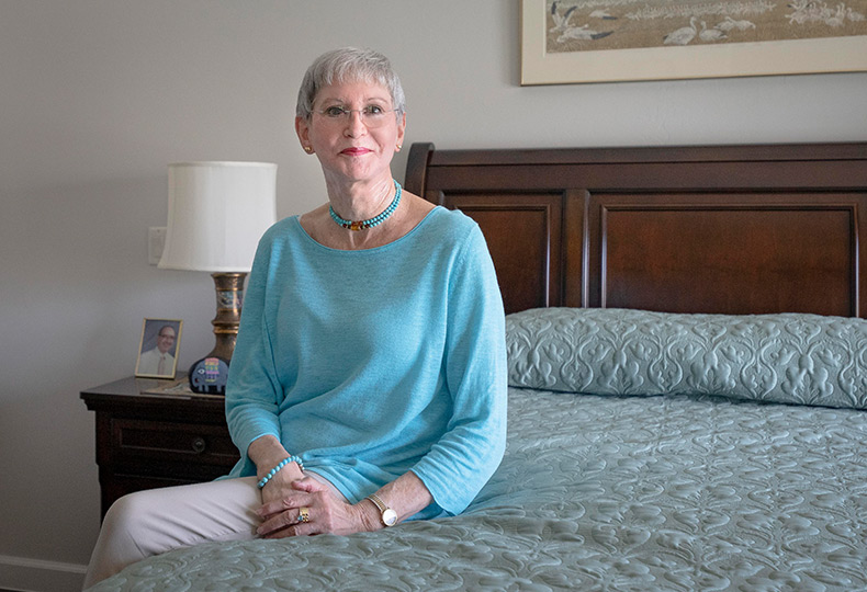 A smiling woman sitting on the bed