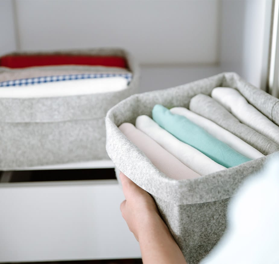 Amenities & Services Watermark at Home Woman organizing clothes in wardrobe, putting shirts in boxes