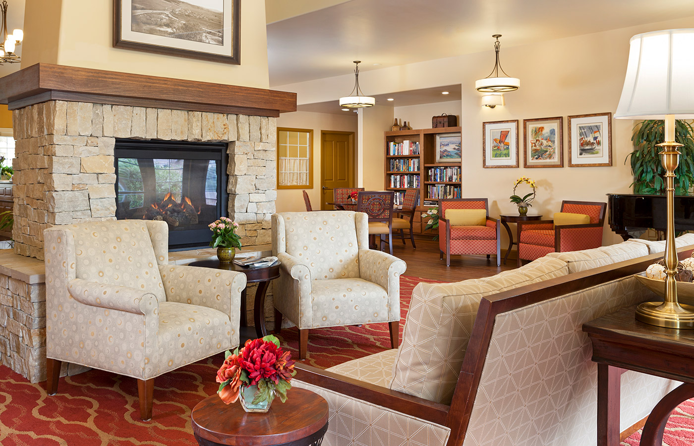 Hall - Gallery Hall with armchair, fireplace and a grand piano in the back by the bright windows