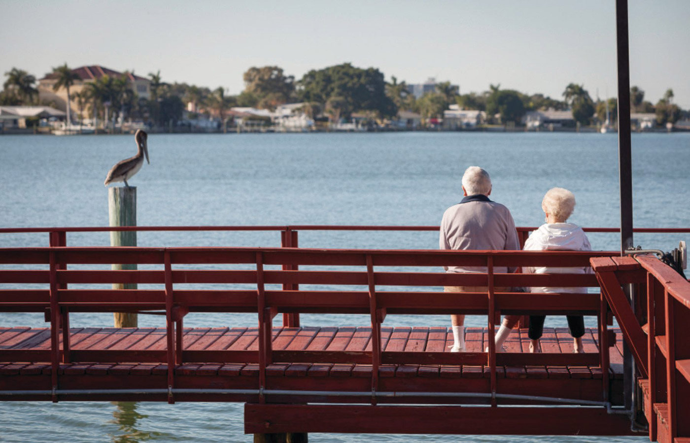 Couple Elderly couple sitting on the pier looking out towards the bay